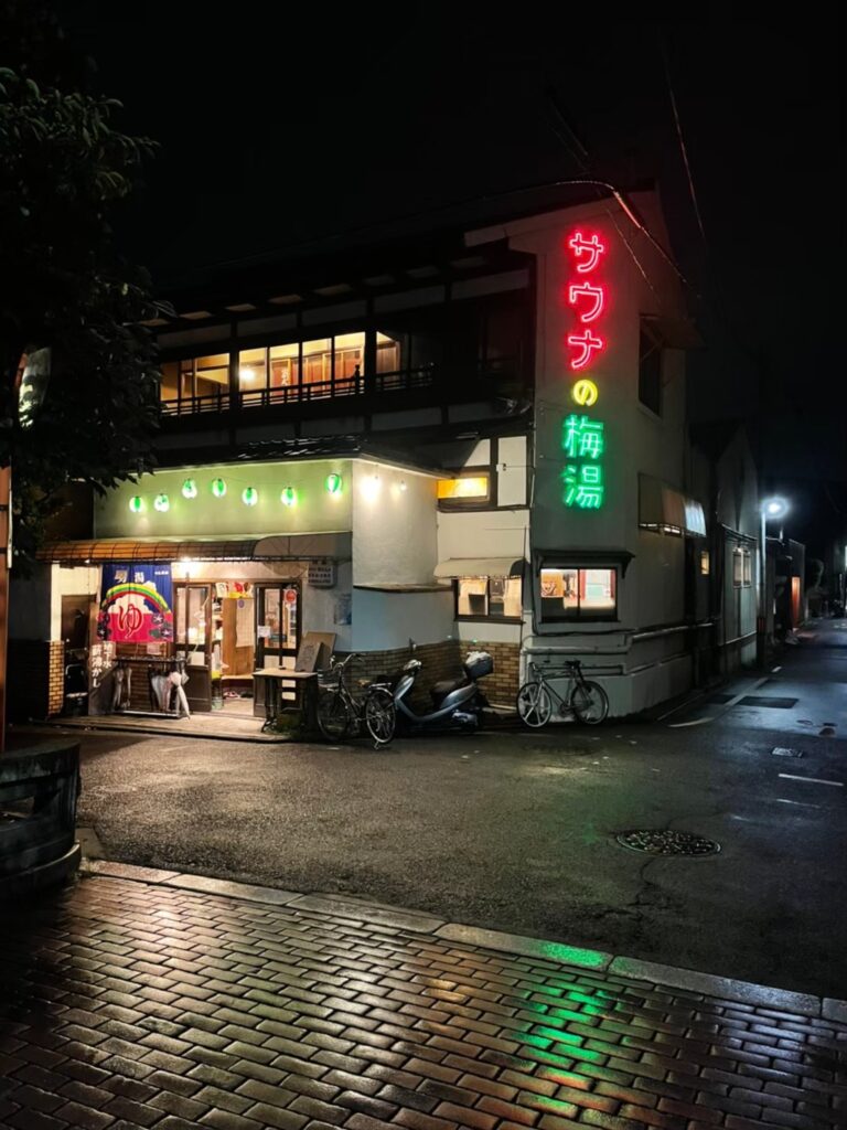 サウナの梅湯 ネオンが光る夜の外観